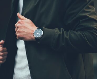 man in green jacket wearing a watch