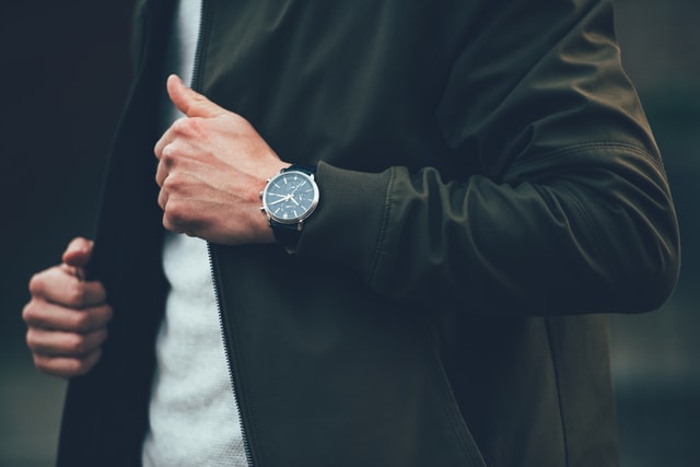 man in green jacket wearing a titan watch