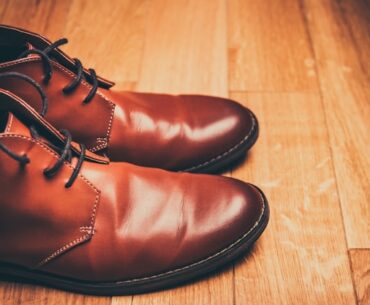 Brown leather shoes on a wooden floor to show bata is not an indian brand